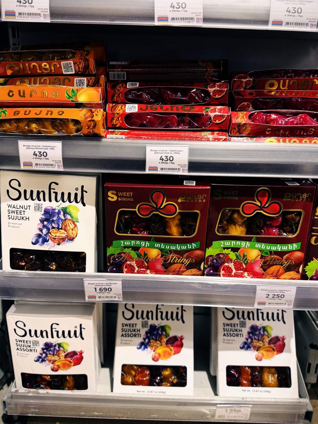 貨架上一排長條盒裝的亞美尼亞核桃甜點 sujukh，標籤價格 430 並掛亞美尼亞三色旗