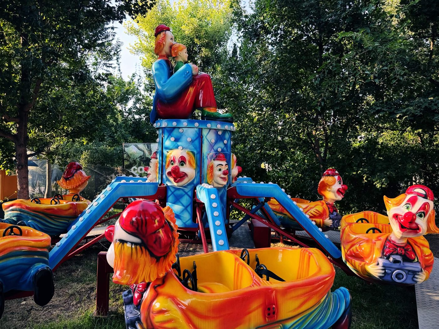 勝利公園內的兒童遊樂設施，一圈小丑造型的彩色乘坐車環繞中央轉盤，塑膠外殼已褪色