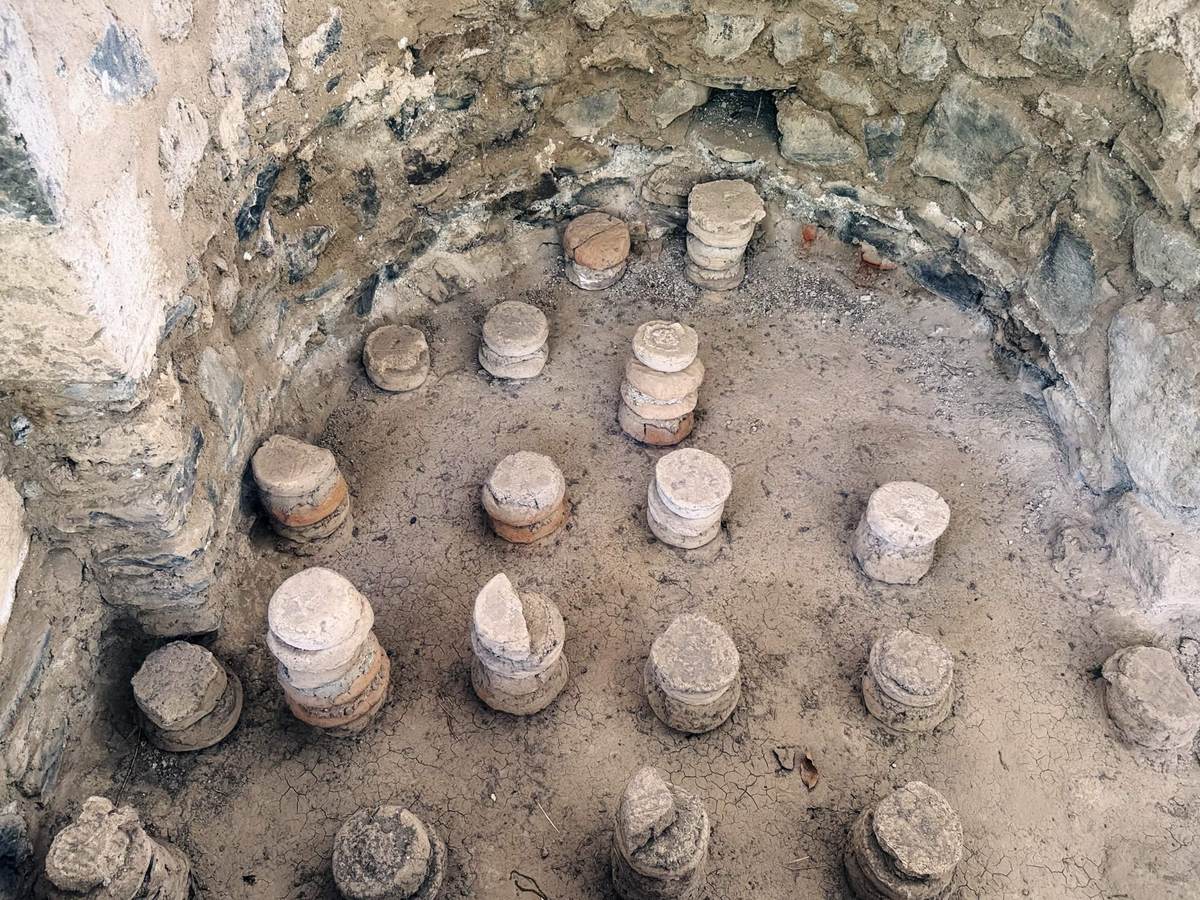 Garni 羅馬式浴場的地暖遺構，地面上排列數十根由圓形陶磚疊成的矮柱墩，用來架高已消失的地板